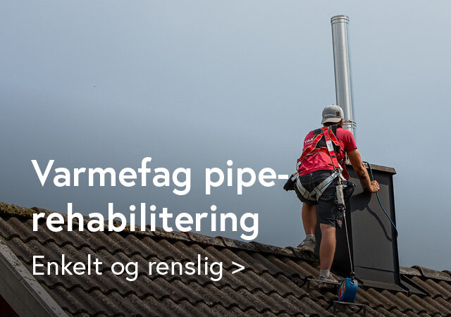 Mann fra Varmefag på taket som tar et stålrør ned i en skortstein for å rehabilitere pipen