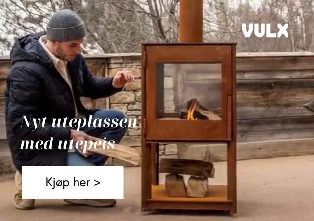 Mann som legger ved utepeis i cortenstål i rustfarge på uteplass med vinter rundt