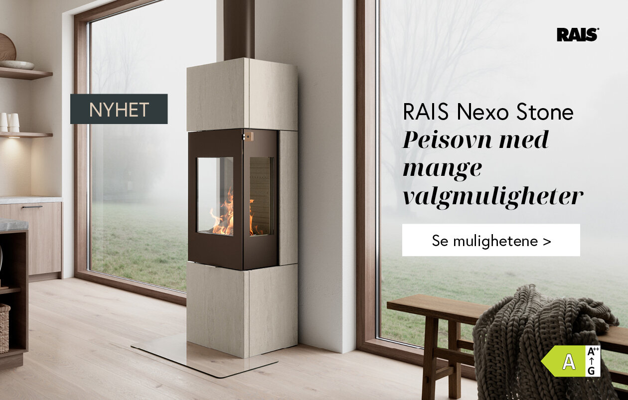 Mørk peisovn med omramming av lys og varmelagrende naturstein i et moderne kjøkkenmiljø med store vinduer