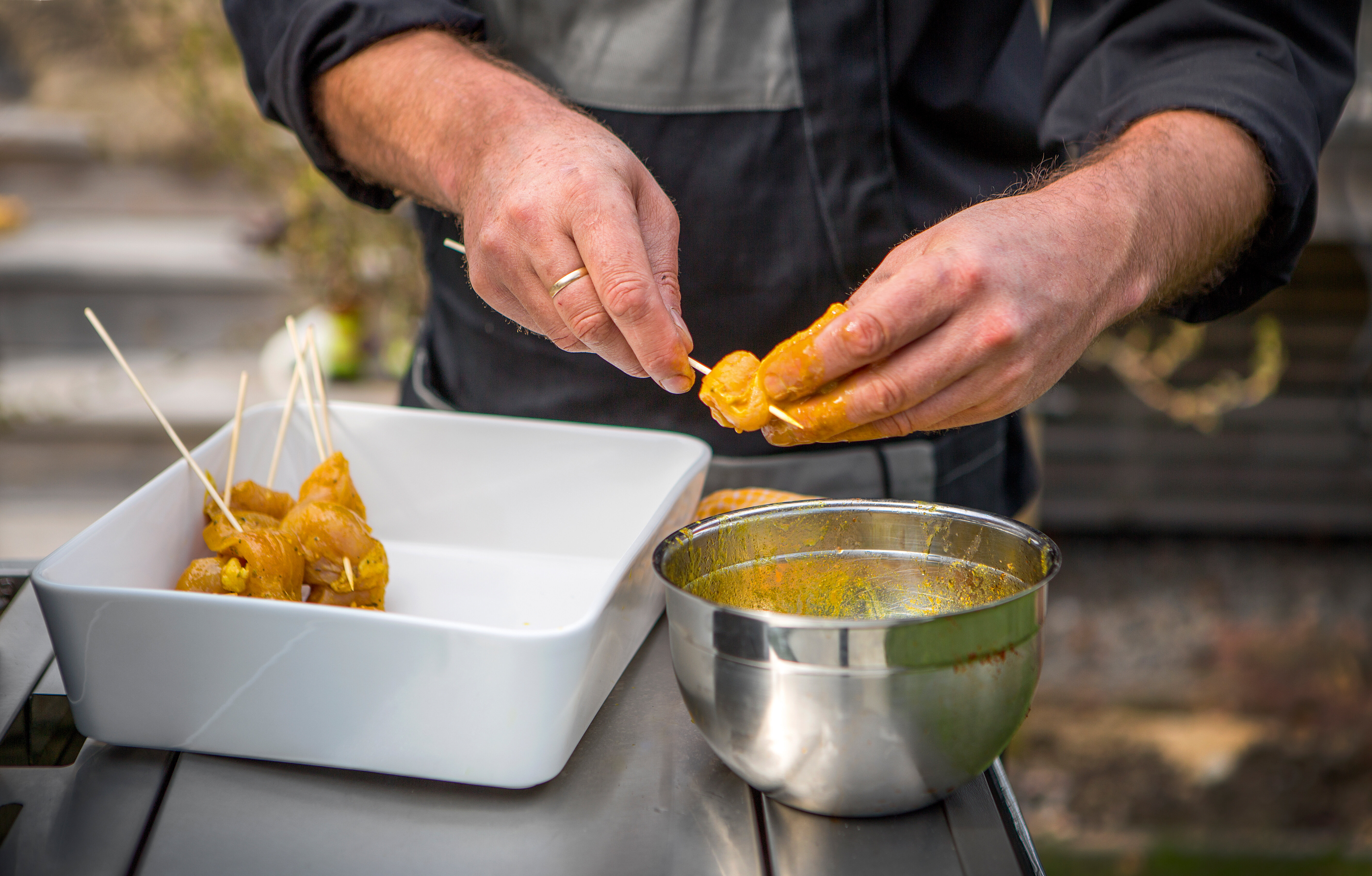 Penseling av kylling på grillen Noen som pensler kylling på grillen