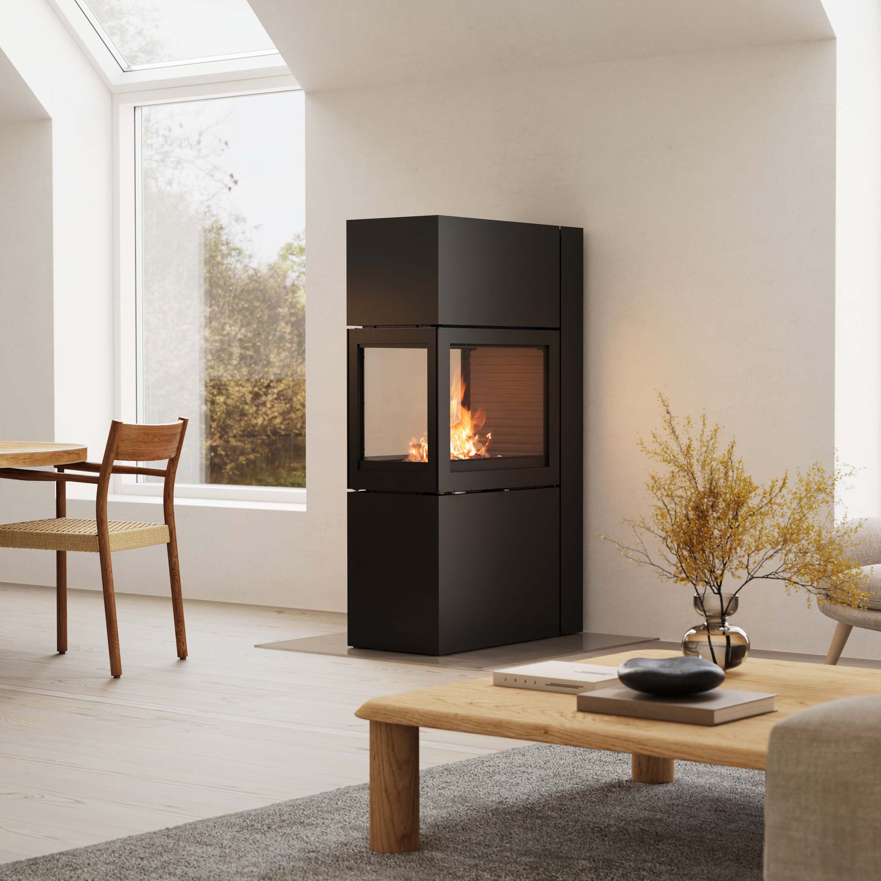 Svart vedovn med fyr i plassert i en lys og moderne stue