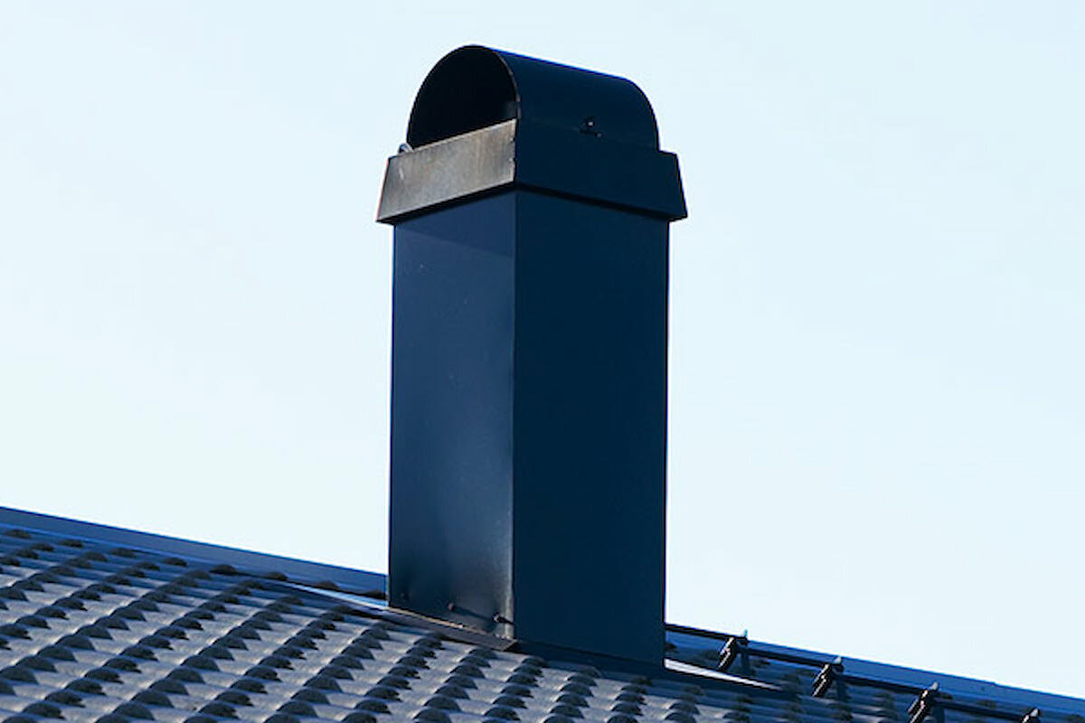 Pipe på et tak med pipehatt på toppen
