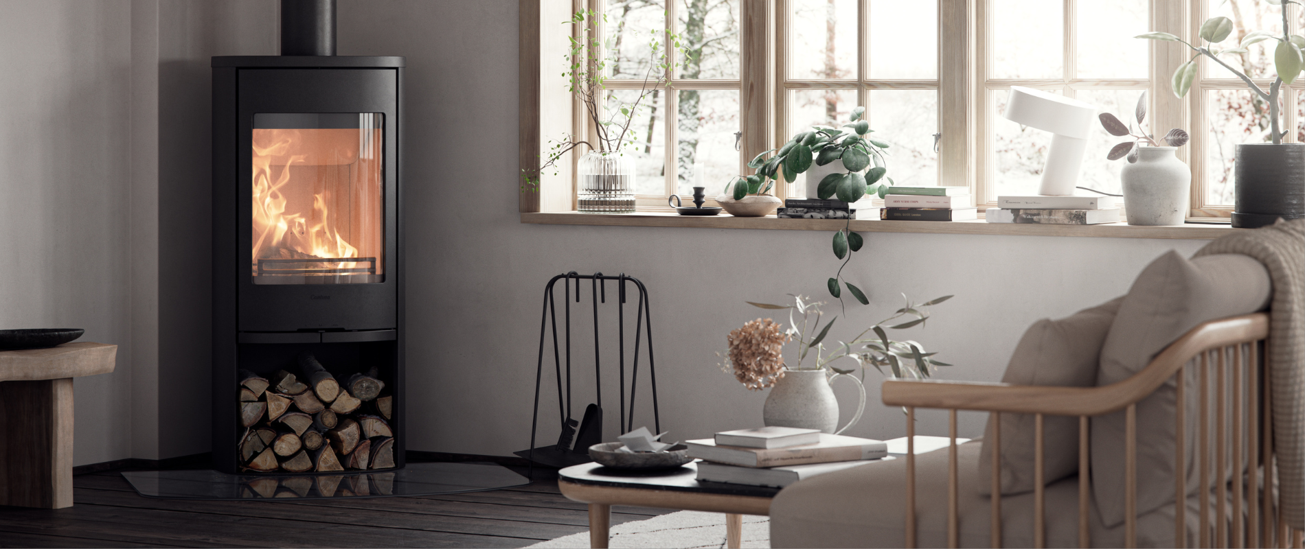 Klassisk svart vedovn med store glassflater med fyr i lys stue