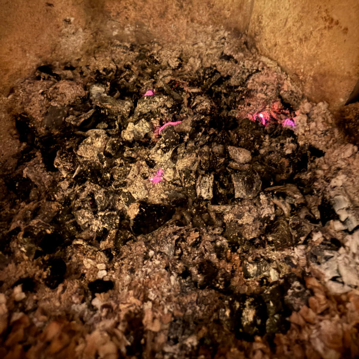 Bilde av glødende aske i en peisovn