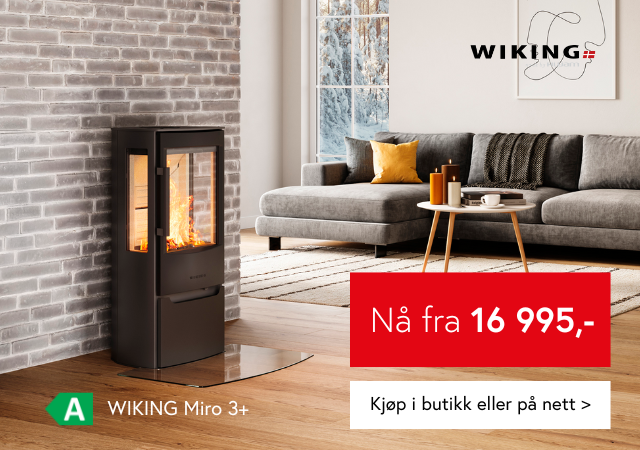 Bilde av en svart peisovn på mursteinsvegg i en lys stue 