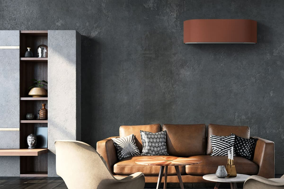 Brun varmepumpe hengt på vegg over en brun sofa i stue